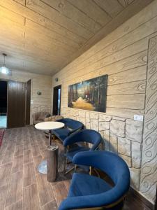 a waiting room with blue chairs and a table at Rabab3a Hotel in Ajloun