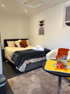 a bedroom with two beds and a table in it at Self-Contained Studio with Ensuite & Private Access in Hardwicke