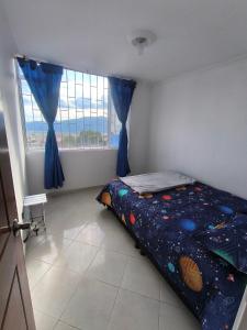 a bedroom with a bed and a large window at Brisas de fusagasuga in Fusagasuga