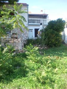 a white house with a tree in a yard at Apartments Elena & Damir in Vis