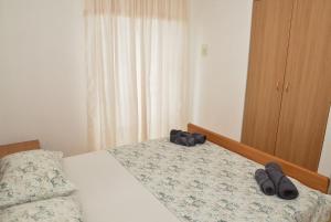 a bedroom with a bed with two pairs of slippers at Blagdan Holiday in Kukljica