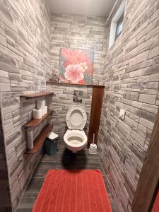 a bathroom with a toilet with a brick wall at Miki Miki House in Fare +28 photos
