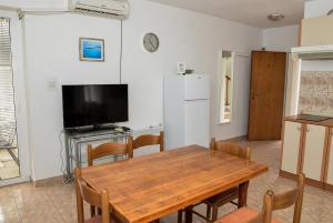 a kitchen and dining room with a table and a refrigerator at Blagdan Holiday in Kukljica