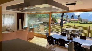 a living room with a table and a large window at Apart Falke 2 am Wasserfall in Unterbach