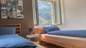 a bedroom with two beds and a large window at Apart Falke 2 am Wasserfall in Unterbach