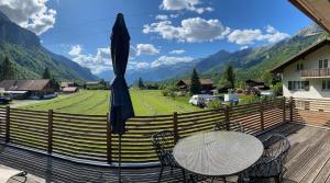 a table and chairs on a deck with a view of mountains at Apart Falke 2 am Wasserfall in Unterbach