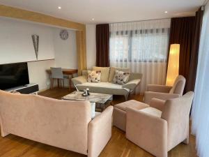 a living room with two couches and a television at Apart Falke 2 am Wasserfall in Unterbach