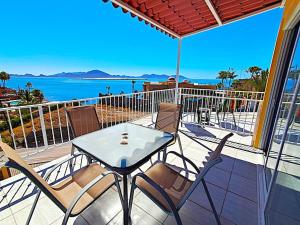 a table and chairs on a balcony with a view of the ocean at Stunning Azul Ocean View Apartment in San Carlos