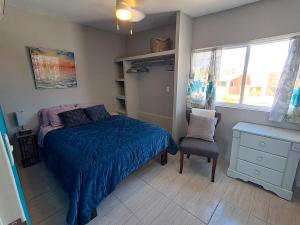 a bedroom with a bed and a chair and windows at Stunning Azul Ocean View Apartment in San Carlos