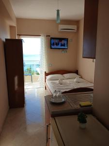 a small bedroom with a bed and a table with glasses on it at RAHI Rooms in Gjilek