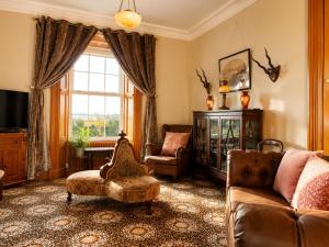 a living room with a couch and a chair and a window at Nore View House in Kilkenny