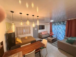 a living room with a bed and a dining room at Miki Miki House in Fare