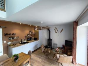 a kitchen and living room with a table and a stove at Ty Noa - 2-bedroom cottage in Saint-Just