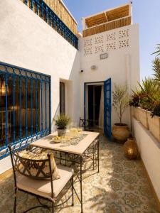 a patio with a table and chairs on a balcony at DAR COLIBRI - Maison de charme à Kélibia in Kelibia