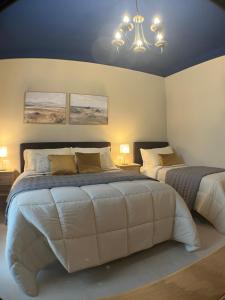 a bedroom with two beds and a chandelier at Harmony Suite in Aprilia