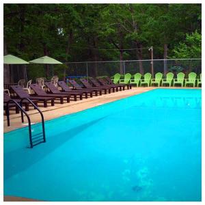 a large swimming pool with chairs and a group at Cabin #1 on Meramec River in Steelville