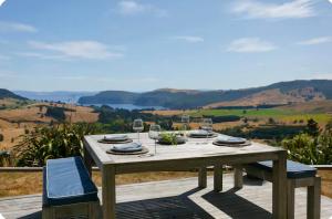 a wooden table with glasses of wine on a deck at Lake Taupo Sunset Lodge in Taupo
