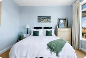 a bedroom with a white bed and a window at Lake Taupo Sunset Lodge in Taupo