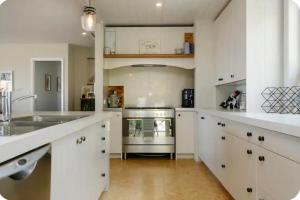 a kitchen with white cabinets and a stove top oven at Lake Taupo Sunset Lodge in Taupo