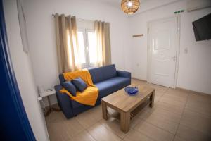 a living room with a blue couch and a coffee table at Blue Water Escape in Agioi Theodoroi