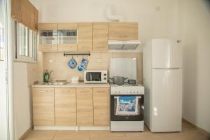 a small kitchen with a refrigerator and a stove at Blue Water Escape in Agioi Theodoroi