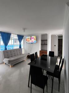 a living room with a couch and a table and chairs at Brisas del Santander in Fusagasuga