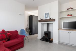 a living room with a red couch and a fireplace at Gorgeous Luxury in Lahinch