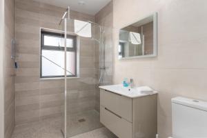 a bathroom with a shower and a sink and a mirror at Gorgeous Luxury in Lahinch +15 photos