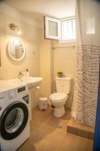 a bathroom with a washer and a toilet and a sink at Blue Water Escape in Agioi Theodoroi