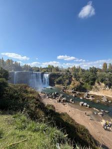 a waterfall with a herd of animals in a river at Cabaña el ricky in Cabrero