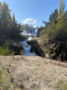 a waterfall in the middle of a river at Cabaña el ricky in Cabrero +4 photos