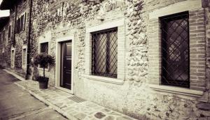 a brick building with two windows and a door at B&B Aurora in Bergamo