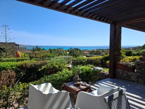a patio with chairs and a table and a view of the ocean at La Finestra su Stintino in Stintino