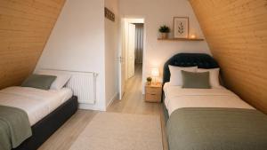 two beds in a small room with a hallway at Cabanele Infinyti in Colibiţa