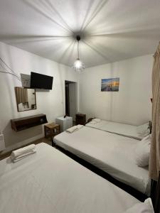 a room with two beds and a television in it at Hotel TSAPARAS in Alíartos