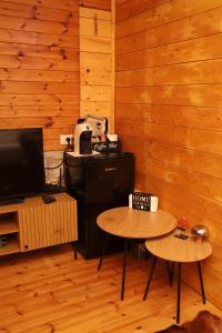 two tables in a room with wooden walls at Airport Comfort Nest in Kamëz