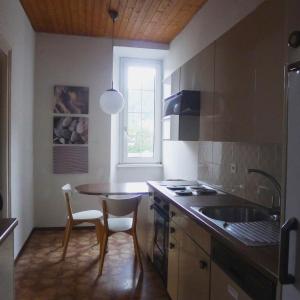 a kitchen with a table and a sink and a window at Casa Jolanda in Bellinzona