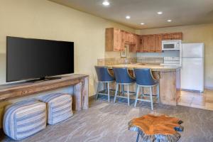a kitchen with a flat screen tv and a bar with stools at Best Western Foothills Inn in Mountain Home