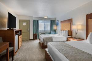 a hotel room with two beds and a flat screen tv at Best Western Foothills Inn in Mountain Home +27 photos
