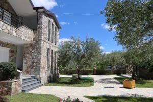 a stone house with a yard with trees at Airport Comfort Nest in Kamëz
