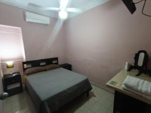 a bedroom with a bed and a ceiling fan at Garcias Suites Cuauhtémoc in Linares