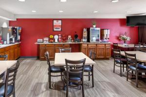 a restaurant with red walls and tables and chairs at Econo Lodge Inn & Suites Oconto in Oconto
