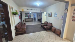 a waiting room with two chairs and a table at Hotel Kolman in Capão da Canoa