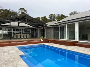 an external view of a house with a swimming pool at Kalamunda Estate with Pool, Fire Pit & BBQ Deck in Bundanoon