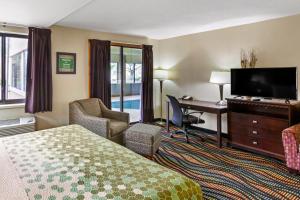 a hotel room with a bed and a desk and a television at Econo Lodge Inn & Suites Oconto in Oconto
