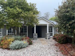 a house with a gravel driveway in front of it at Kalamunda Estate with Pool, Fire Pit & BBQ Deck in Bundanoon