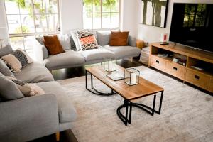 a living room with couches and a coffee table at Kalamunda Estate with Pool, Fire Pit & BBQ Deck in Bundanoon