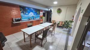 a restaurant with a table and chairs in a room at Hotel Kolman in Capão da Canoa