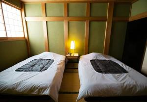 two beds in a room next to a window at 鈴籠城 鈴の間 - ダブルベッド2台 - 最大4名 in Nagahama
