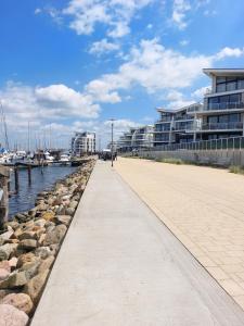 a walkway next to a marina with buildings at Apartment Nordly in Wendtorf
